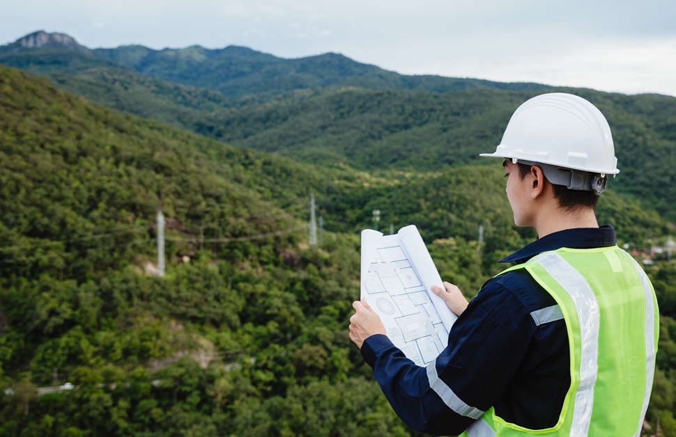 A land surveyor looking over the proposed site of a development as part of a landscape visual impact assessment