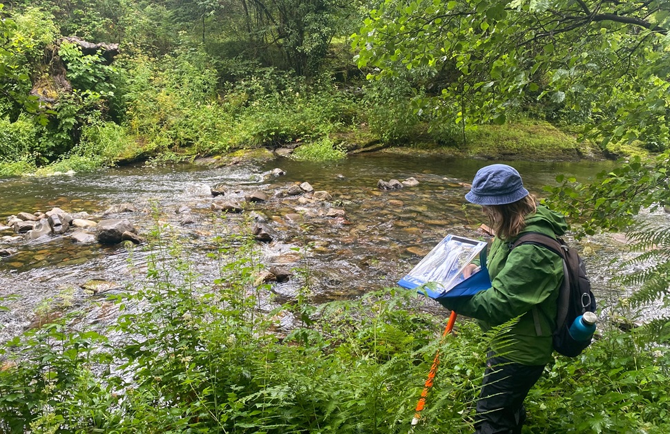 A river condition assessment specialist going through notes taken from a survey