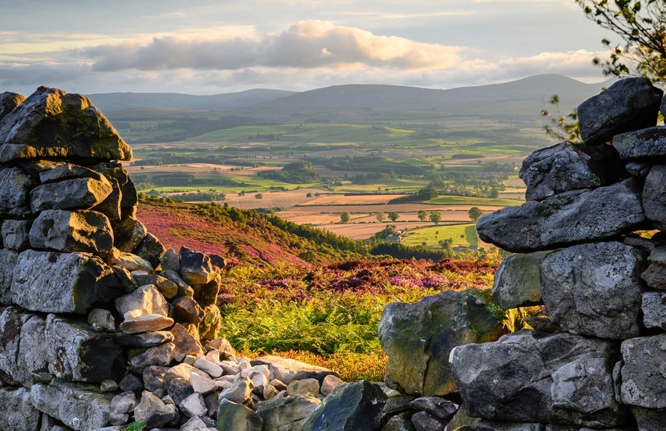 A historic landscape in England surrounded by a damaged heritage wall