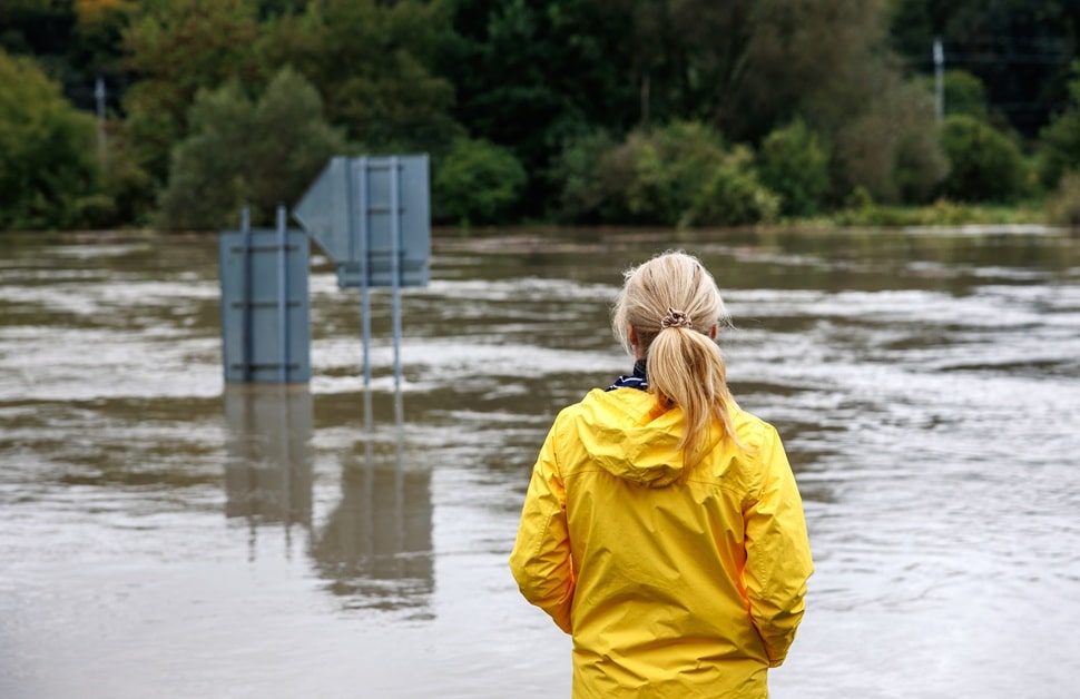 A flooded river being reviewed by a flood risk consultant
