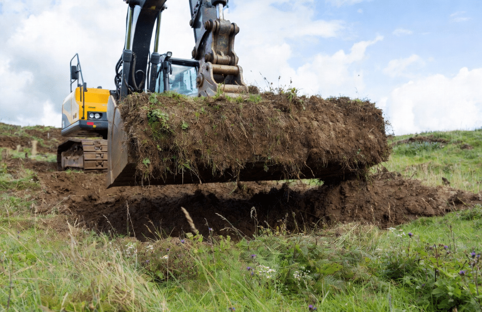 A digger carrying out turf translocation on a site as part of habitat creation services