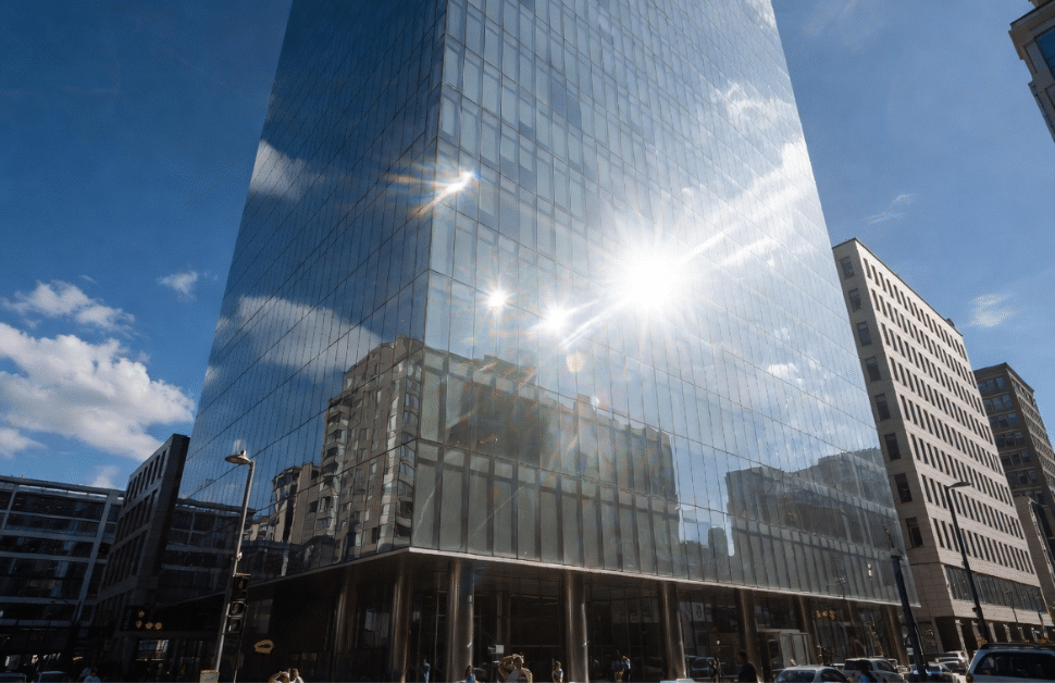 A building in a city with the windows experiencing glint and glare